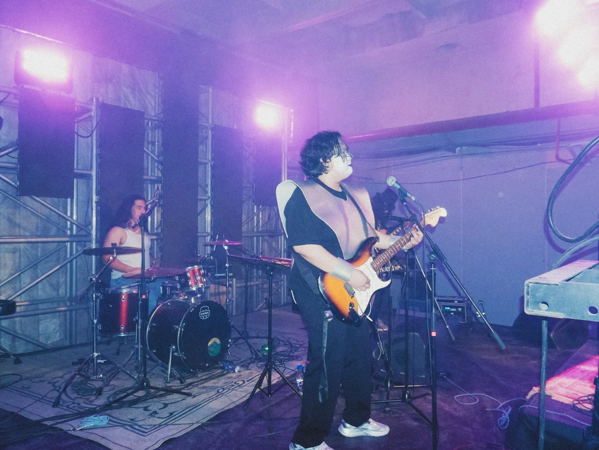 A band on a violet-lit stage